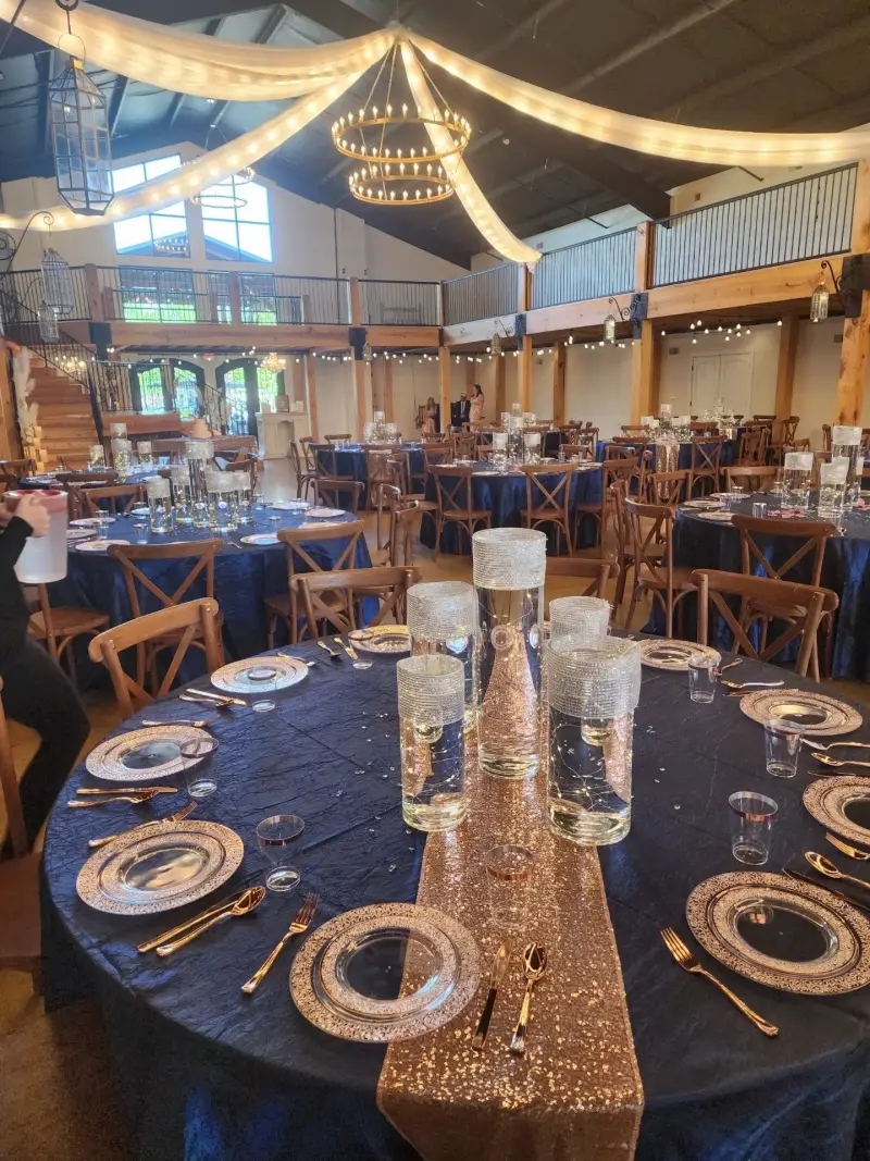 Navy and gold place settings beneath warm string lights