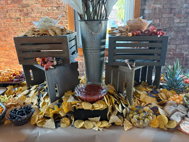 Tortilla chip and salsa station built from black crates on a grazing table