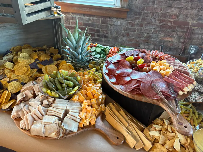Charcuterie board of salami, cheeses and crackers on a grazing table